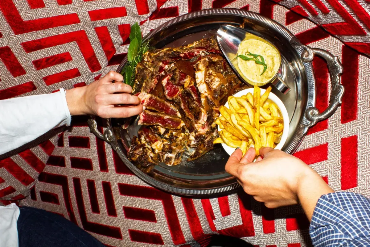Plat signature : viande grillée et frites, présenté sur plateau argenté rétro au restaurant Madame Claude