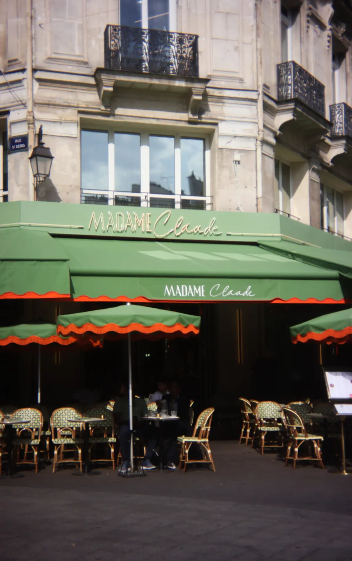 Façade du restaurant Madame Claude, 2 rue Berger à Paris 1er : terrasse vert clair et enseigne néon rétro