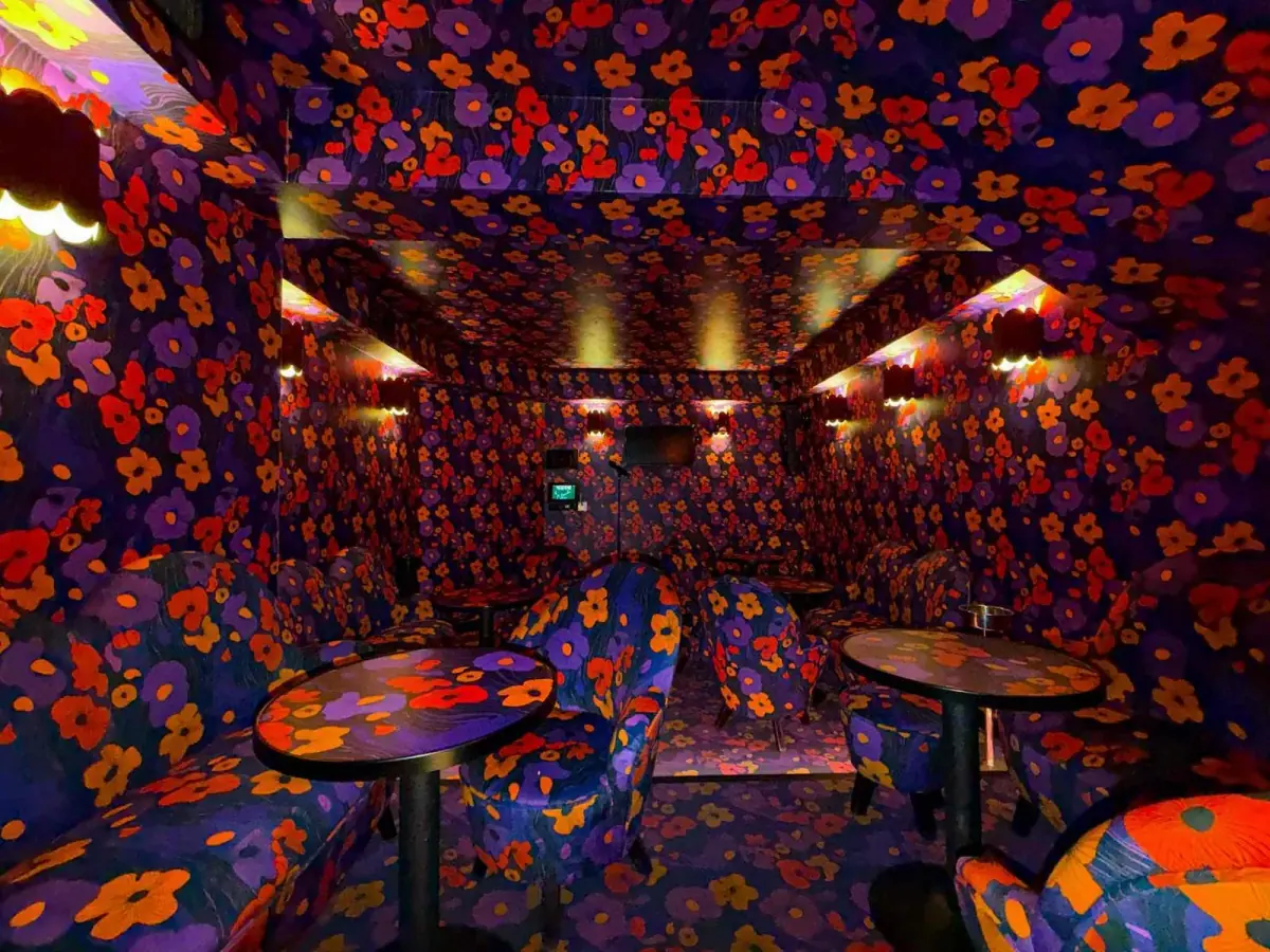 Salle privative Poppy : décoration florale années 70 et ambiance intimiste pour karaoké et événements privés